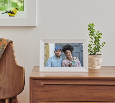 White digital picture frame from Aura Frames Carver model on a desk